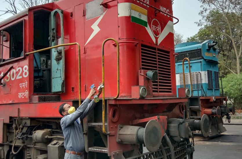 Railway workers sanitizing diesel engines in diesel loco sheds.
