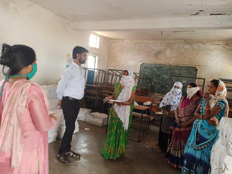Self help group women preparing a book for school