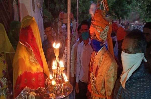 चित्तौडग़ढ़ में सोमवार रात एक विवाह समारोह में मास्क लगाए दुल्हें की आरती उतारते वधु पक्ष के परिजन।