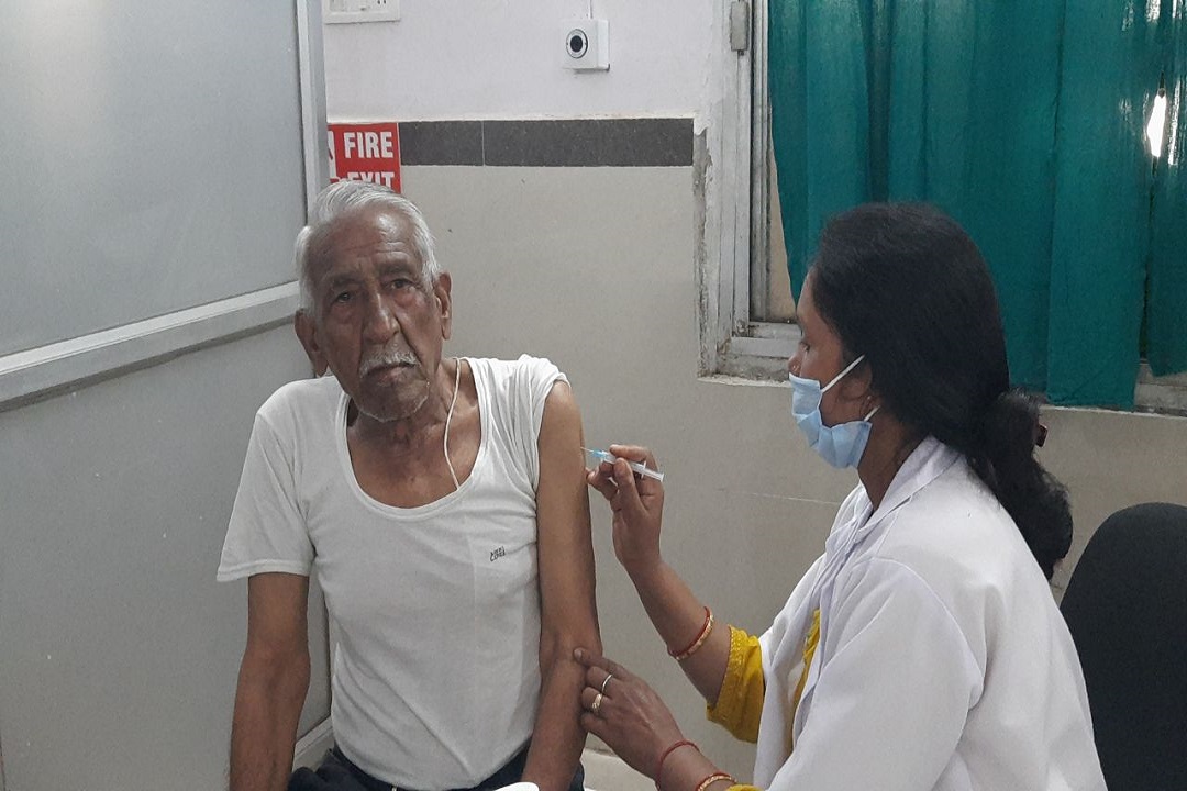 कोरोना का टीका लगवाते बुजुर्ग
