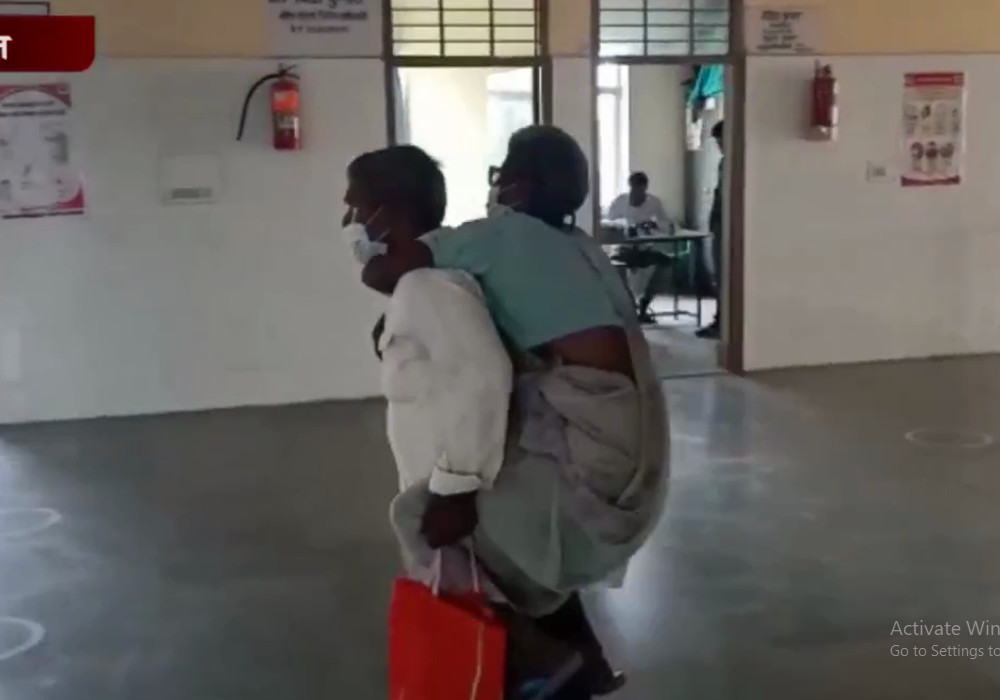 अस्पताल में इलाज के लिए बूढ़ी मां को पीठ पर लाद कर घूमता रहा बेटा, वीडियो वायरल