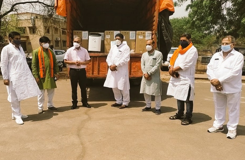 BJP officials give the collector a machine.