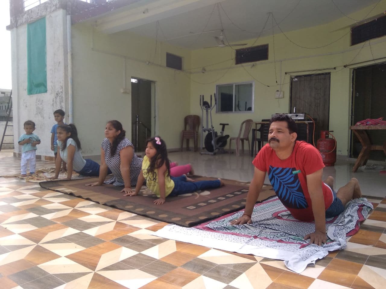 World Yoga Day: Youth and elders practice yoga with children at home,