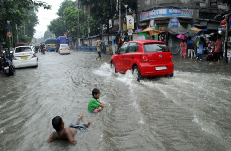 कॉलेज स्ट्रीट पर भरे पानी में मस्ती करते बच्चे।