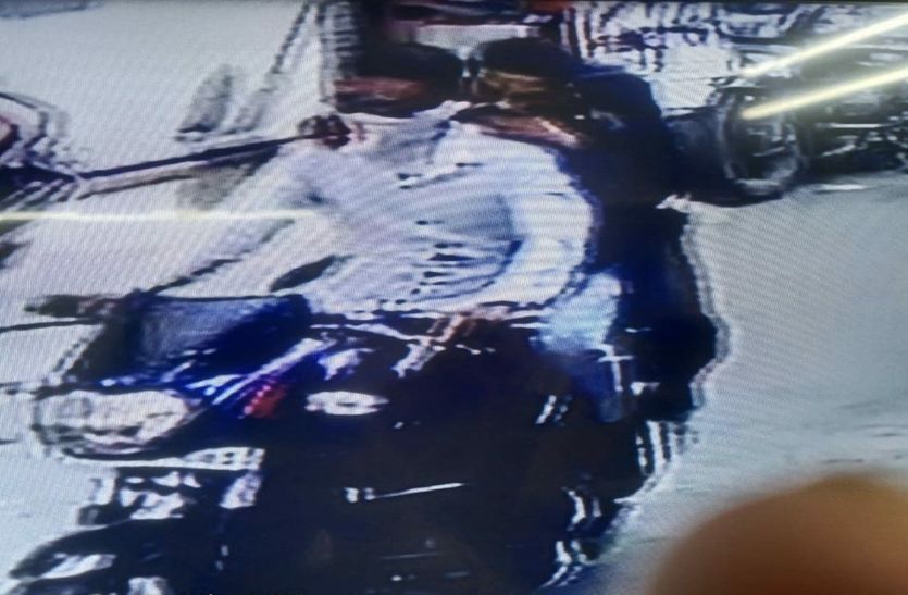 Three people riding the bike of a woman who was buying vegetables ran