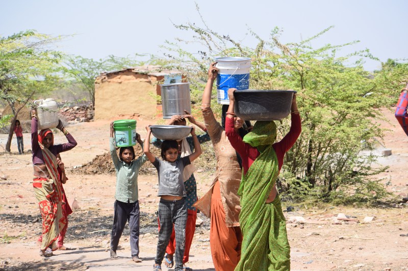 गोली पुरा गांव में पेयजल किल्लत के चलते गंदी पोखर में खोदी गई कुई से पानी भर कर लाती महिलाएं