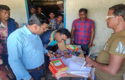 दस्तावेजों की जांच करते विभाग के अधिकारी।