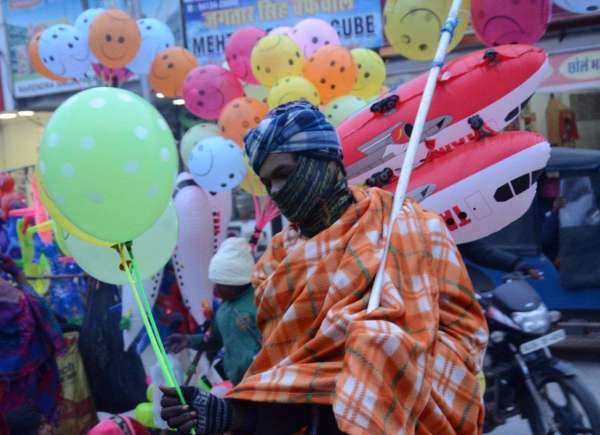 श्रीगंगानगर के गोलबाजार स्थित डॉ भीमराव अंबेडकर चौक के पास शाम को ठिठुरन ठंड व घने कोहरे के चलते गुब्बारे बेचने के दौरान सर्दी से बचने के लिए गर्म कपड़ो में लिपटे हुए।