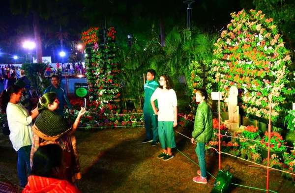 फूलों के साथ लोग ले रहे सेल्फी