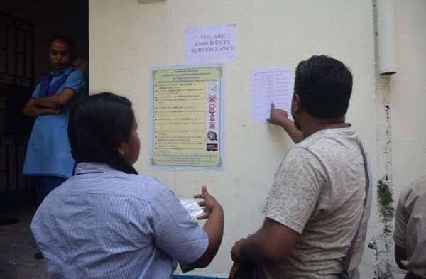 परीक्षा केंद्र पर रोल नंबर देखते छात्रा के अभिभावक।