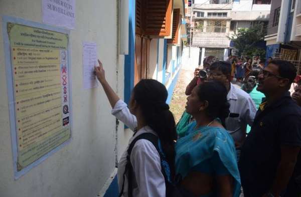 परीक्षा केंद्र में रोल नंबर से अपना परीक्षा रूम देखती छात्राएं।