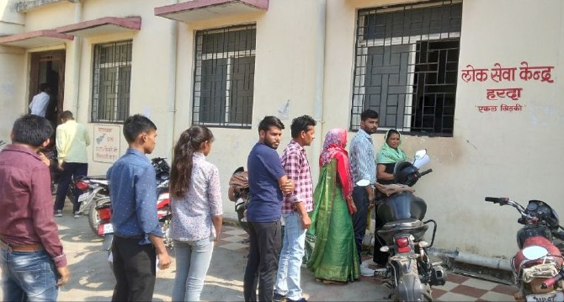 धूप में खड़े रहकर फार्म जमा को मजबूर महिलाएं