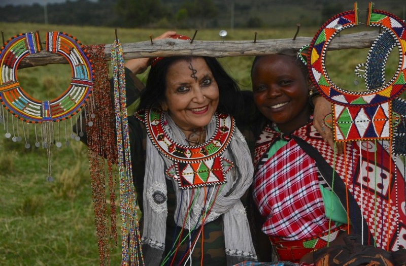 मसाई जनजाति के गांव में हाथ से बनाए गए पारंपरिक आभूषणों के साथ जनजातीय महिला और लेखिका।