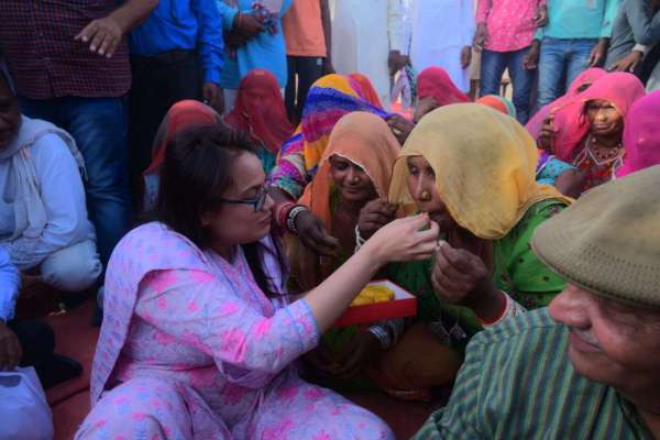 महिलाओं का मुंह मीठा करवाते हुए  