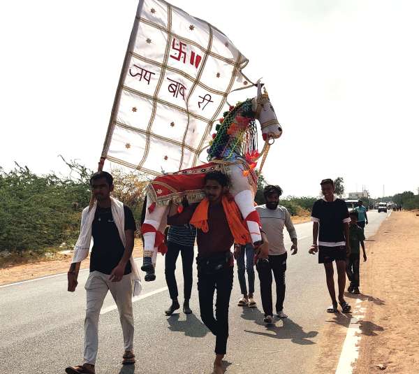  ध्वजा व घोड़ा लेकर जाते श्रद्धालु