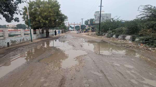 बरसात की बूंदों के साथ खुली सड़कों की पोल