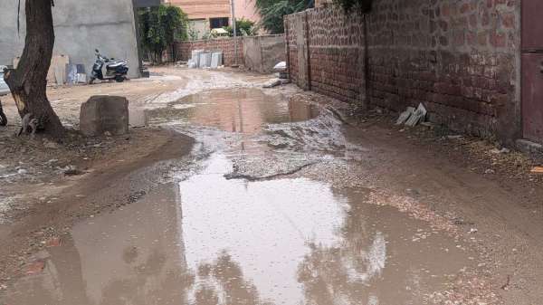 बरसात की बूंदों के साथ खुली सड़कों की पोल