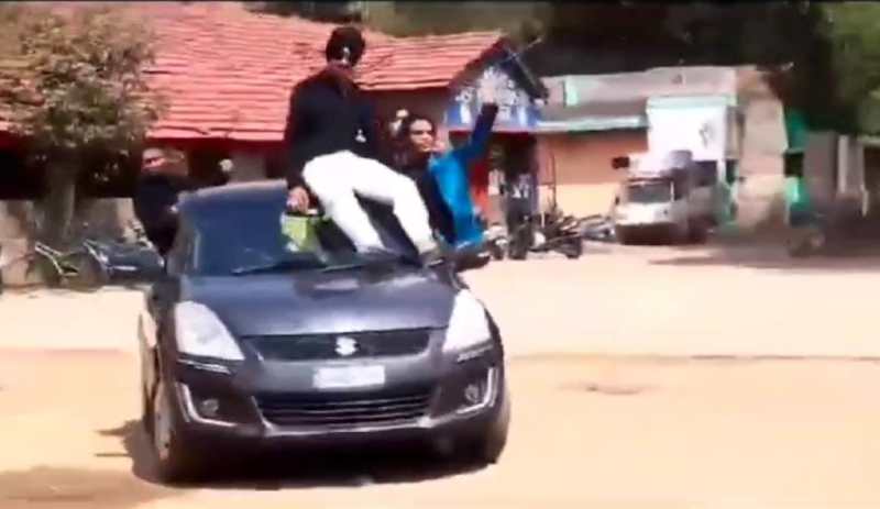 चलती कार की खिड़की से बाहर निकलकर व ऊपर बैठकर छात्रों का स्टंट