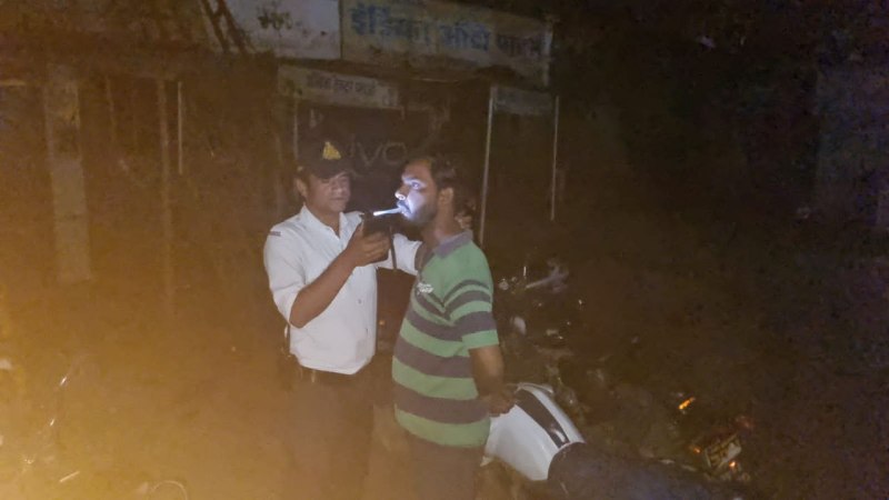 ब्रीथ एनालाइजर से जांच करता यातायात पुलिसकर्मी