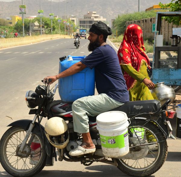 माकड़वाली रोड देवनगर अपने दुपहिया वाहन पर पानी भरकर ले जाता युवक।
