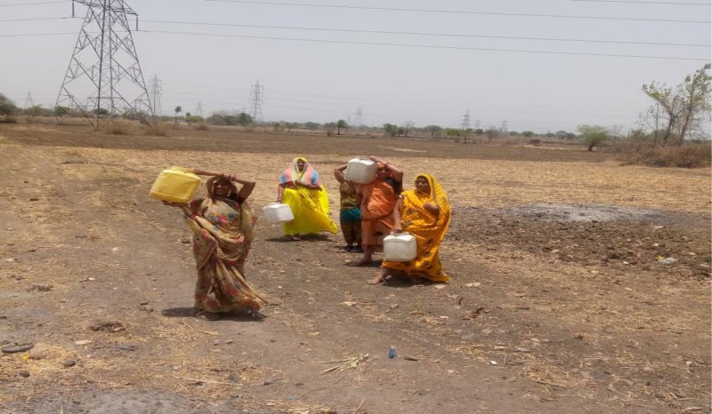 Women walking one kilometer in the scorching sun to get a pitcher of water