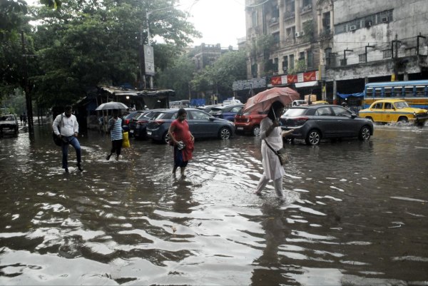 धर्मतल्ला की जलमग्न सडक़ से गुजरते लोग। 
