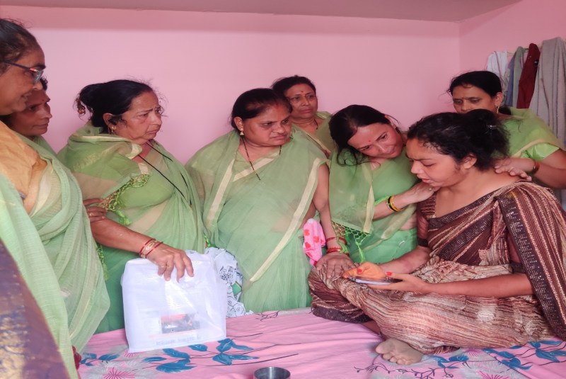 बेसुध हुई शहीद की पत्नी हाथ में मोबाइल लेकर पति को कॉल लगाती। उनको समझाइश देते संगठन की अध्यक्ष व सदस्य।