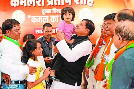 कार्यक्रम के दौरान बच्ची को गोद में लेकर दुलार करते सीएम।