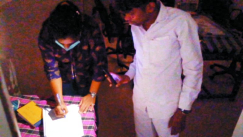 टॉर्च की रोशनी में मरीज के लिए पर्चा लिखते डॉक्टर।