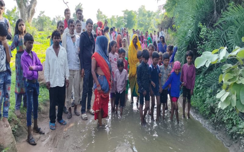 रमपुरा खिरक की दलदल युक्त सडक़ के पास ग्रामीण।