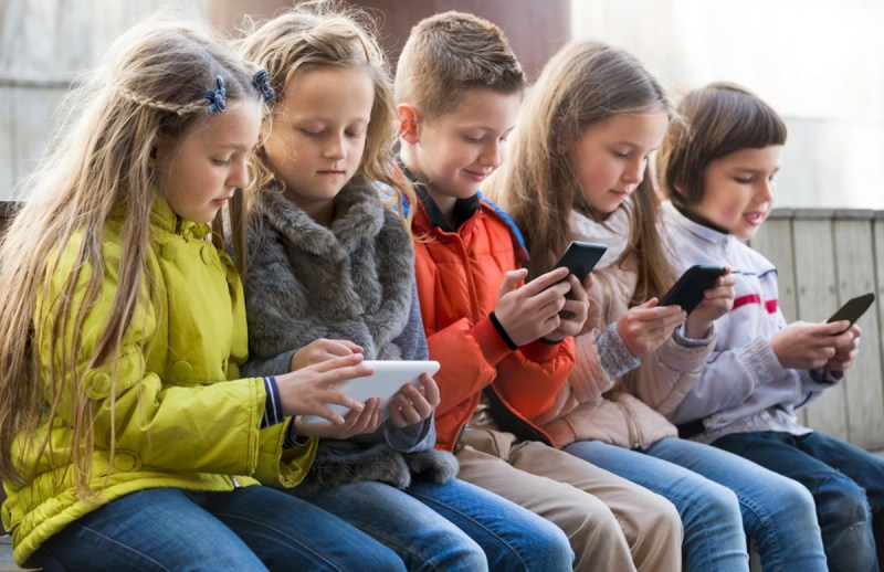 Children using smartphones in School