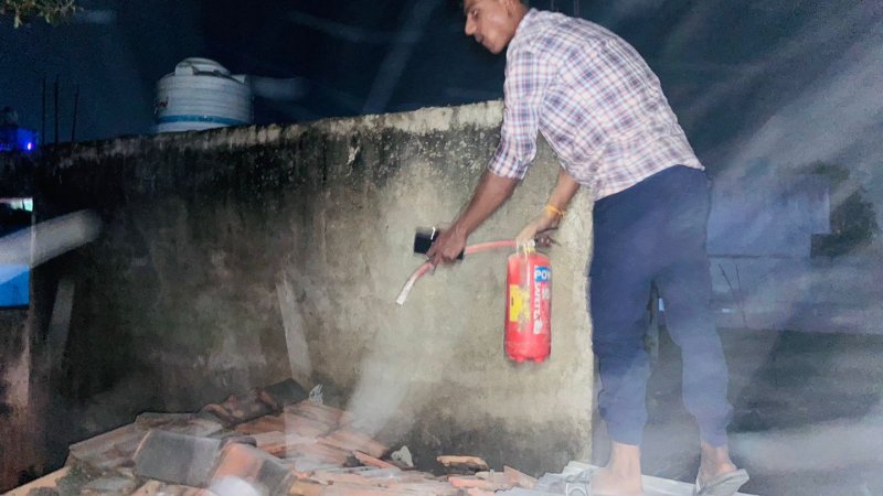 आग बुझाता कर्मचारी