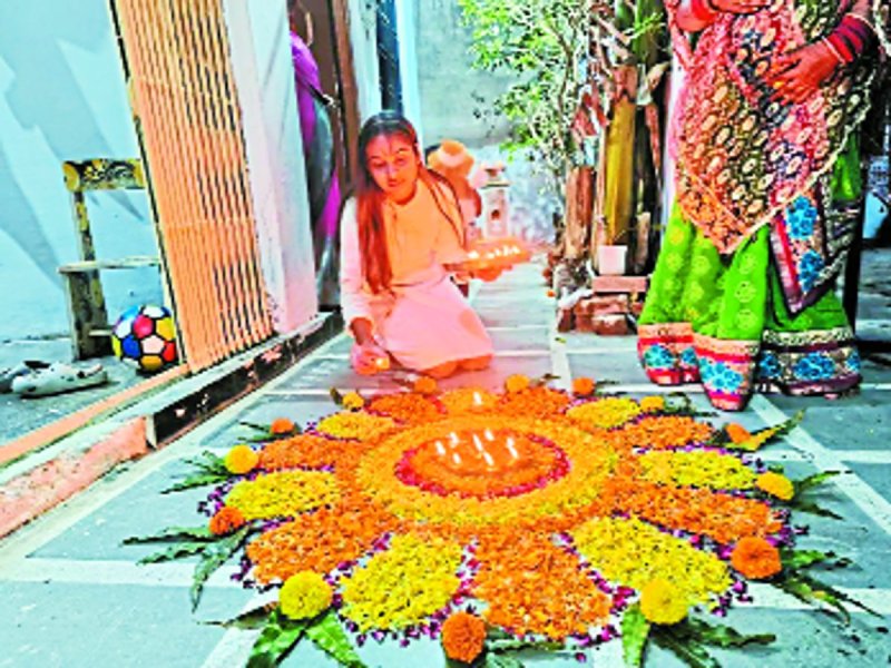 पूजन के लिए रंगोली सजाती बालिका।