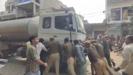दुर्घटनाग्रस्त टैंकर को धक्का देकर पीछे करते पुलिस के जवान