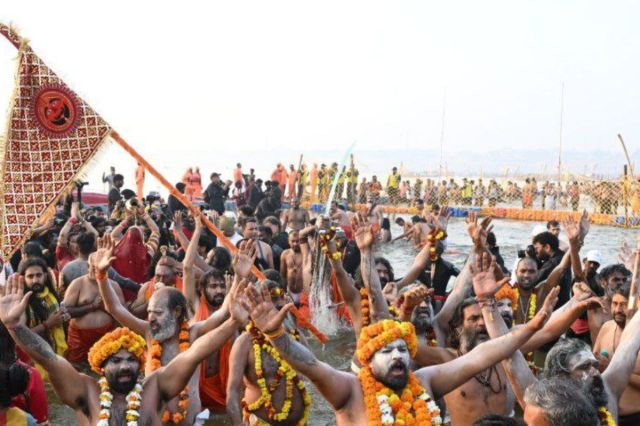 Sadhus waving flags during the holy dip