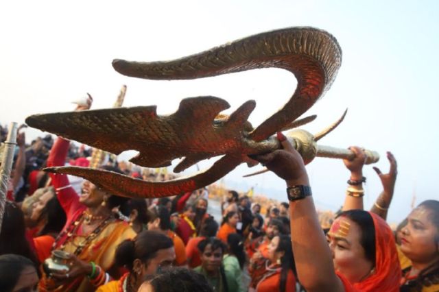 Sadhvi waving a trident during the holy dip