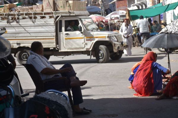 Traffic policemen resting in the shade and traffic rules being broken in the city