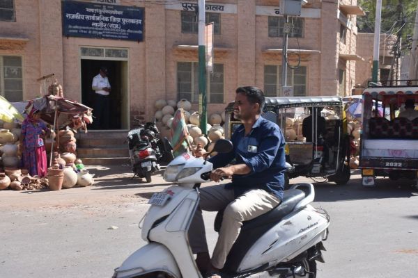 Traffic policemen resting in the shade and traffic rules being broken in the city