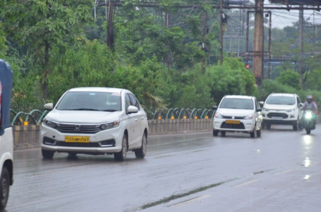 राजधानी रायपुर में रिमझिम के दौरान गुजरते वाहन।