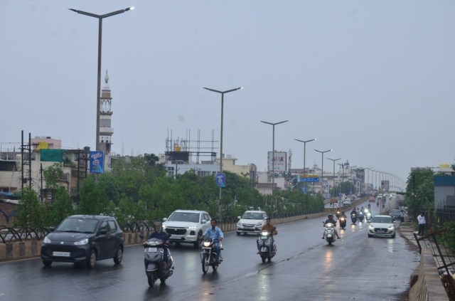 राजधानी रायपुर में रिमझिम के दौरान गुजरते वाहन।