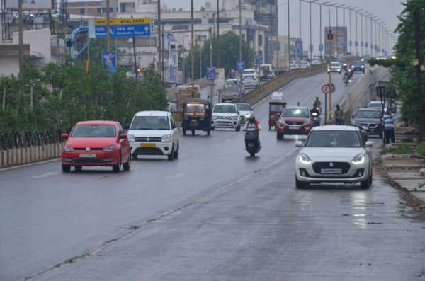 राजधानी रायपुर में रिमझिम के दौरान गुजरते वाहन। 