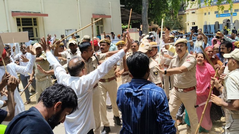 कलक्ट्रेट गेट पर बैठे लोगों को हटाती पुलिस।