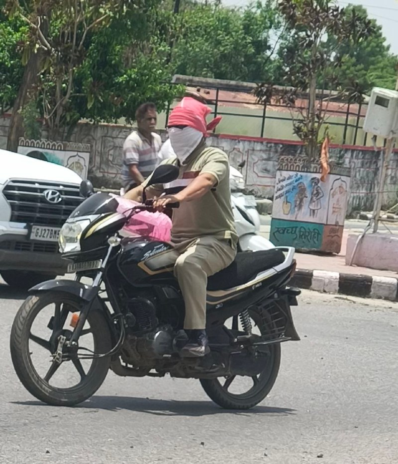 सिरोही. दोपहर के समय तेज धूप से बचने के जिए मुंह पर कपडा ढक कर मोटरसाइकिल पर जाता युवक।