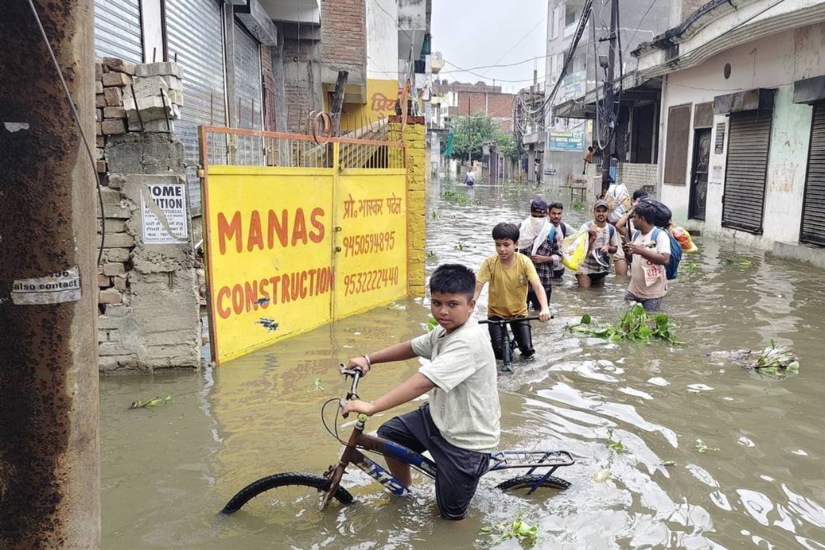 बाढ़ के पानी में मस्ती करते हुए बच्चे।