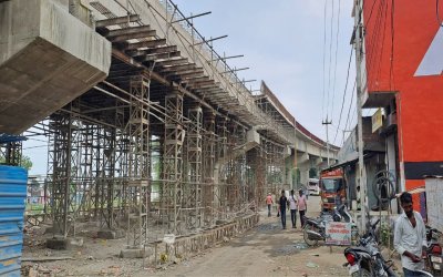 Employees are working unsafely on the overbridge, people passing below remain in danger
