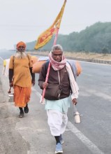 झंडा लेकर पैदल यात्रा करते पूर्व शिक्षा अधिकारी।