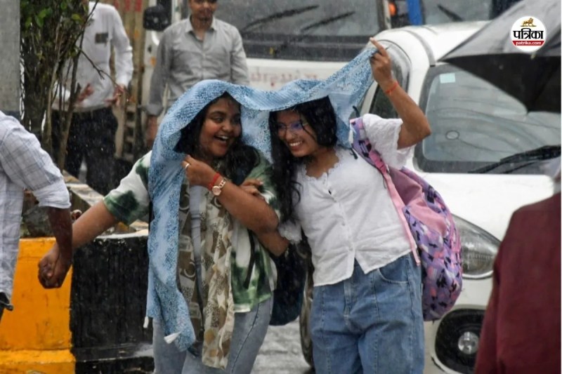 बारिश के बीच गुजरती युवतियां।