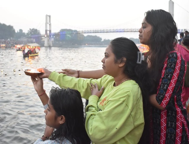 स्नान के बाद सूर्यदेव को जल अर्पण कर दीपदान करते श्रद्धालु।