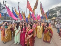 निशान यात्रा में श्रद्धा का रंग: हाथों में निशान लिए सहभागी महिलाएं।