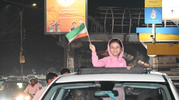 हाथों में तिरंगा लिए बालिका जीत की खुशी मनाती हुई।